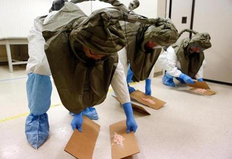 Dr. Edy Kim and nurses Deb Buonopane and R.N. Catherine Robinson cleaned up a spill while learning how to treat an Ebola patient during a training session at Brigham and Women's Hospital on Oct. 22. 
