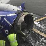 The engine on a Southwest Airlines plane is inspected as it sits on the runway at the Philadelphia International Airport after it made an emergency landing in Philadelphia, Tuesday, April 17, 2018. (Amanda Bourman via AP)