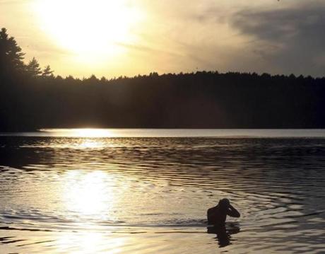 FILE ? Alex Meyer, an open-water swimmer, trains at Walden Pond in Concord, Mass., Oct. 11, 2011. Henry David Thoreau?s classic ?Walden? is the inspiration for a new video game that urges players to collect arrowheads, cast their fishing pole into a soothing pond, buy penny candies and perhaps even jot notes in a journal ? all while listening to the author?s meditations on nature. (Alex Trautwig/The New York Times)
