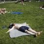 People laid out in the grass on the Rose Kennedy Greenway.