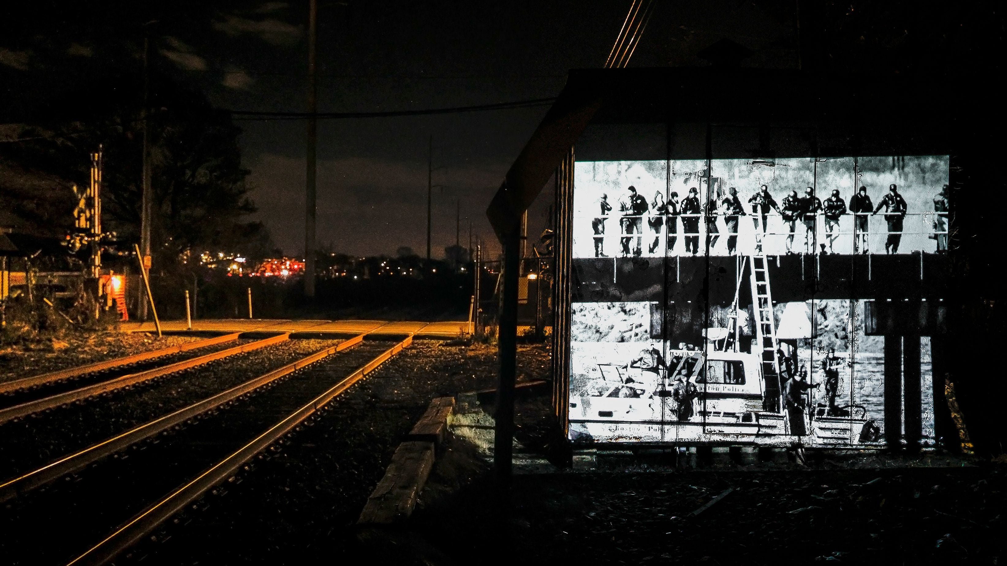 A photo from 1990 is projected nearby the train tracks leading to Dizzy Bridge.