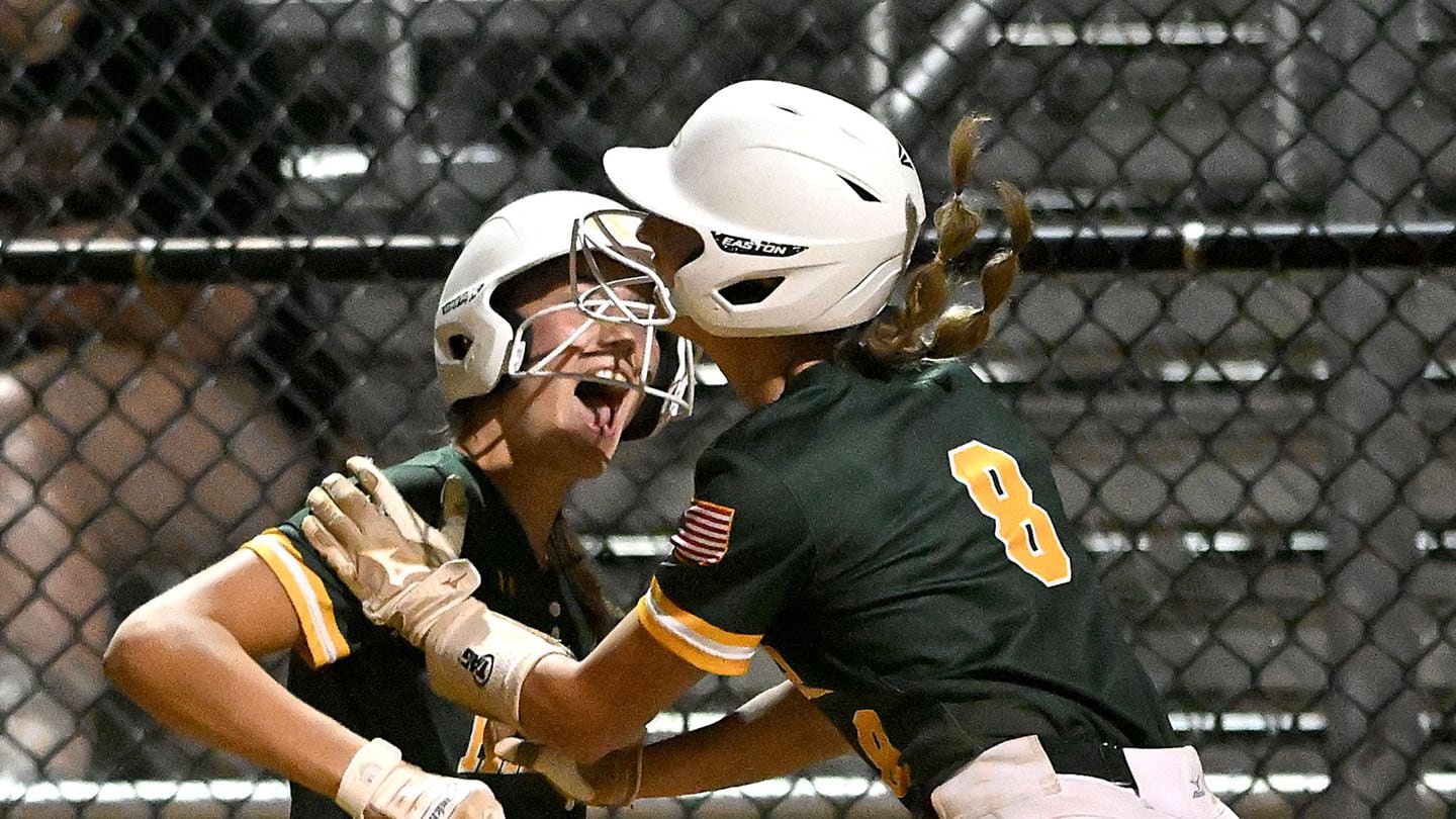 King Philip’s Ava Kelly (No. 8) leaps into teammate Maddie Paschke after scoring the go-ahead run in the 10th inning of the Division 1 semifinal against Wachusett at  Worcester State University.