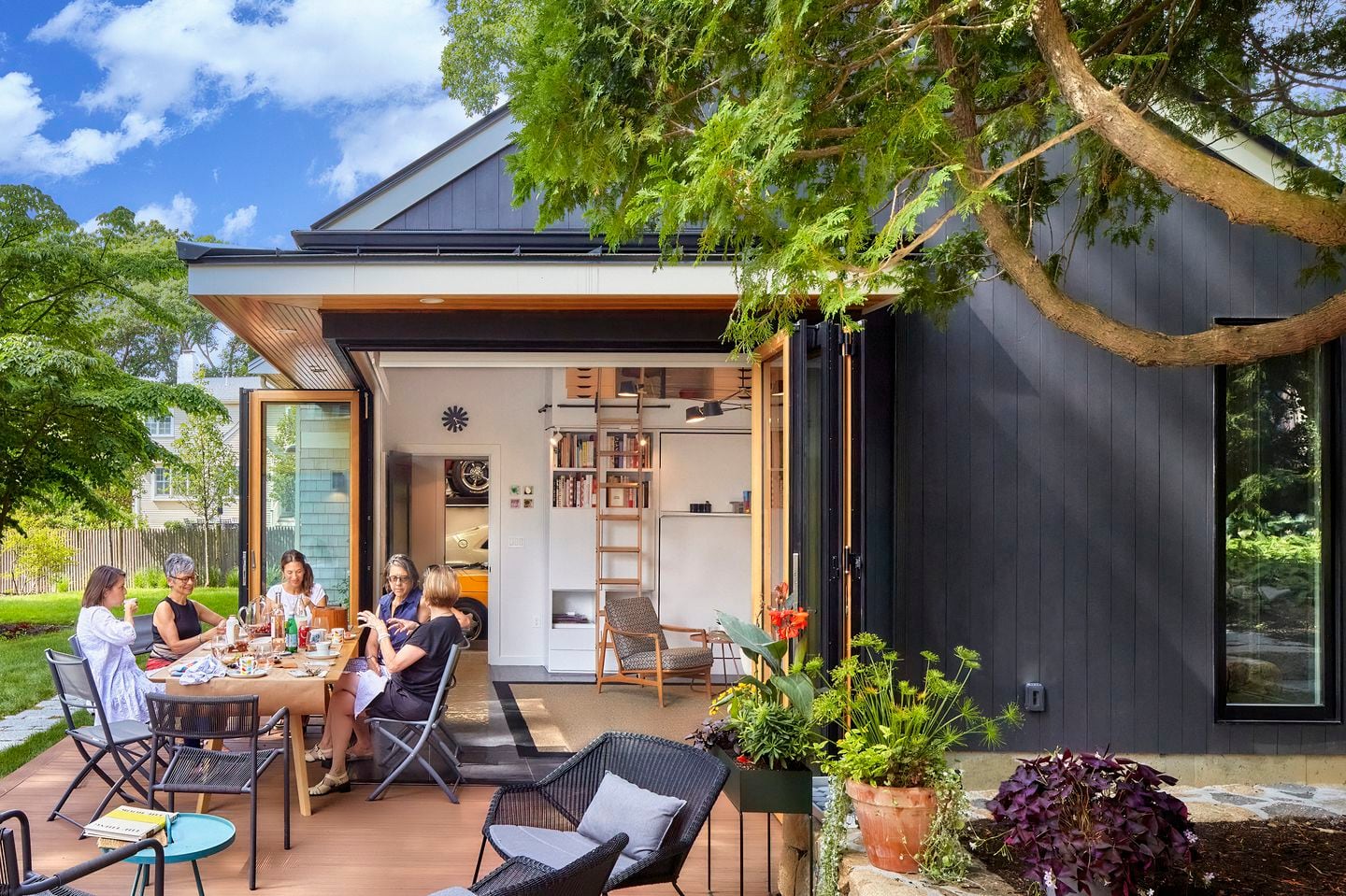 Stacked accordion doors on this Needham accessory dwelling unit allow Jan Moscowitz to open two sides of the studio to the outdoors, where she often entertains.