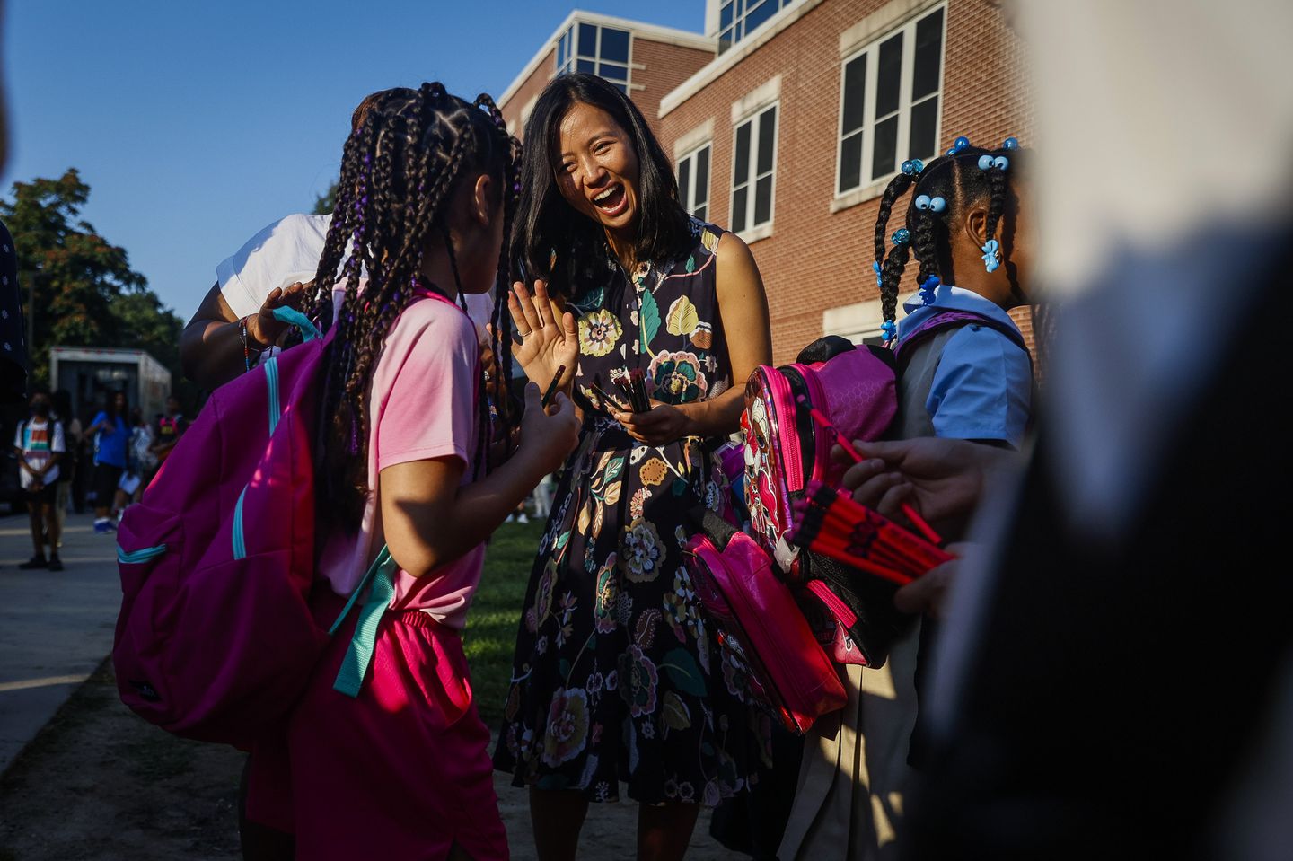 Boston Mayor Michelle Wu, pictured greeting students as they arrived to Mildred Ave K-8 School in Dorchester for the start of school in September, 2023, is facing criticism from some who say she is slow-walking making politically painful decisions about school closures.