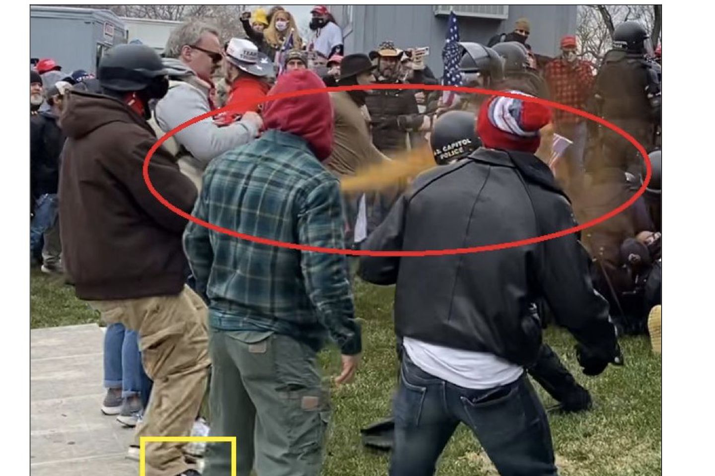 A photo released by the FBI allegedly shows Christopher Belliveau (at left in brown hoodie and khaki cargo pants) directing pepper spray at a US Capitol Police officer.