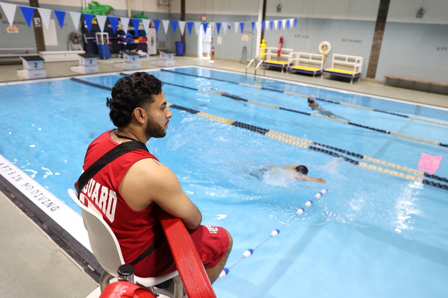 Cristian Parra, a lifeguard at Boston's Mason Pool, watched over swimmers as they swam laps.