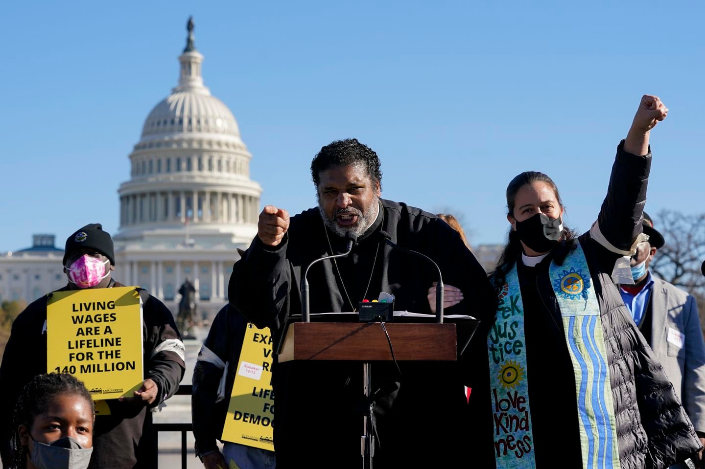 Rev. William Barber, center, at a rally in Washington, D.C., in December 2021. Barber's new book, 'White Poverty,' extolls America's moral obligation to all poor people, including the white ones.
