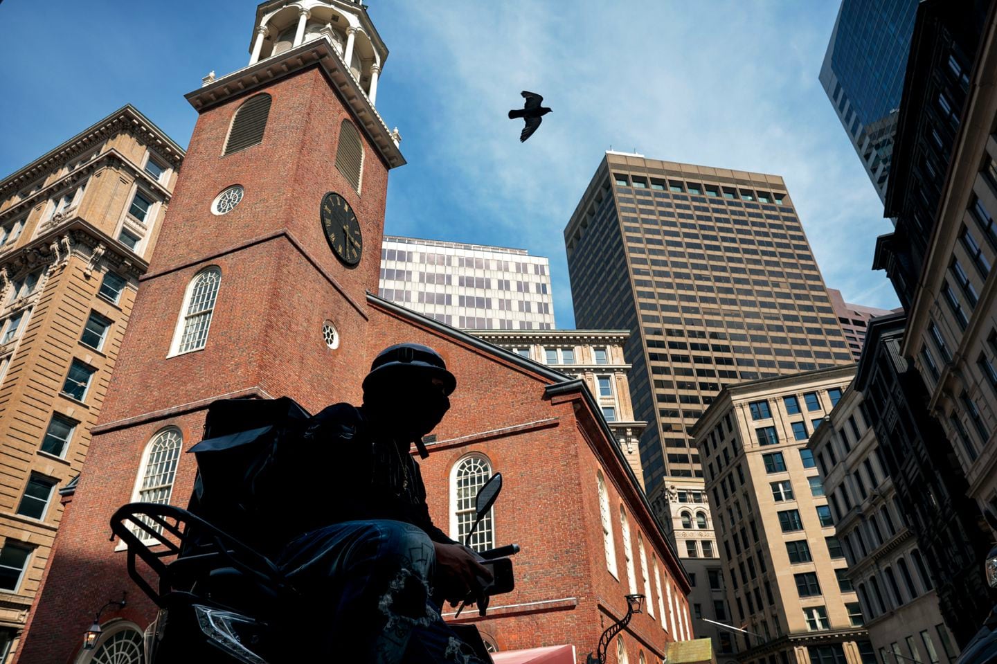 A food delivery driver from the Dominican Republic, who identified himself by his first name, William, waited for an order across from the Old South Meeting House at Downtown Crossing in Boston on June 4, 2024.