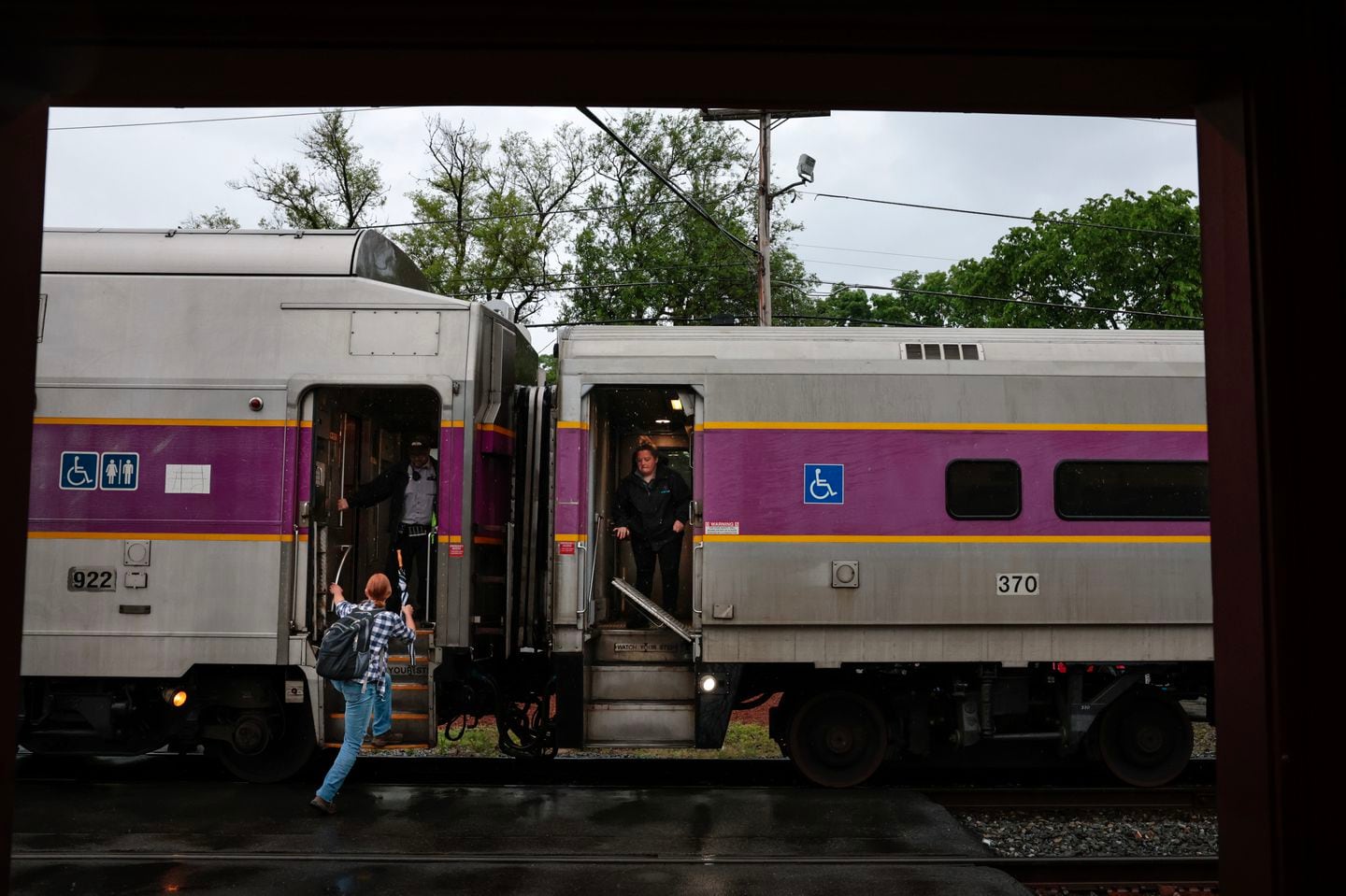 A commuter hoisted herself onto an inbound train at the MBTA Fitchburg Line commuter rail station in Shirley, Mass.