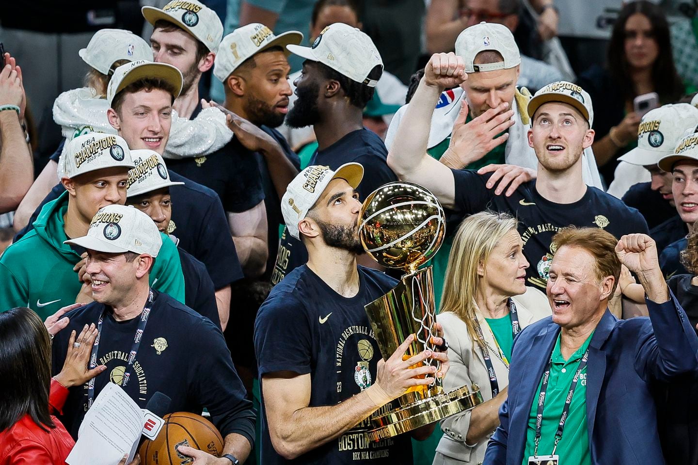 Jayson Tatum kissed the Larry O'Brien Trophy after winning the NBA Finals on Monday. Team co-owner Steve Pagliuca is at right.