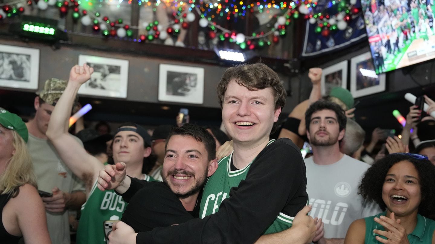Celtics fans Michael Cole (left) and Owen Maceachern (right) hugged at The Greatest Bar Monday to celebrate the Celtics winning the NBA Finals.
