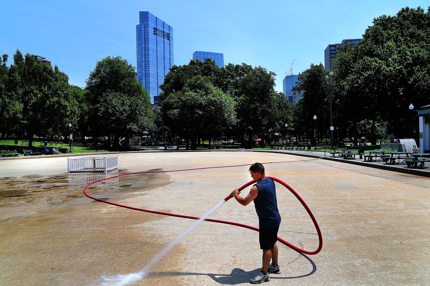 Jean Farias washed down the surface of the Boston Common Frog Pond which will open June 25th.