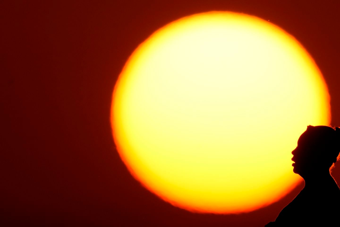 A woman was silhouetted against the setting sun on a day with a triple-digit heat index last August in Kansas City, Mo.