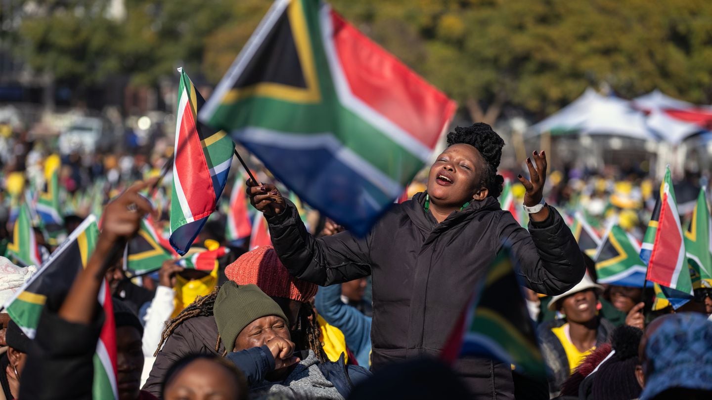 People wave the flag of South Africa in celebration before the inauguration of President Cyril Ramaphosa to a second term in Pretoria on Wednesday.
