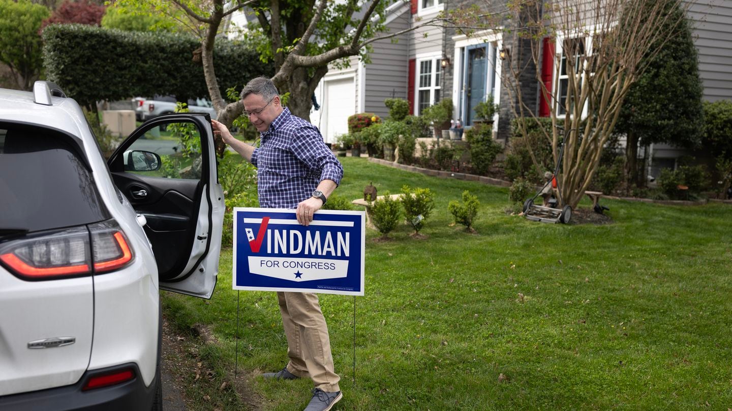 Yevgeny “Eugene” Vindman, who is running for Congress in Virginia, took a campaign sign out of a car while canvassing in Occoquan, Va., April 9.