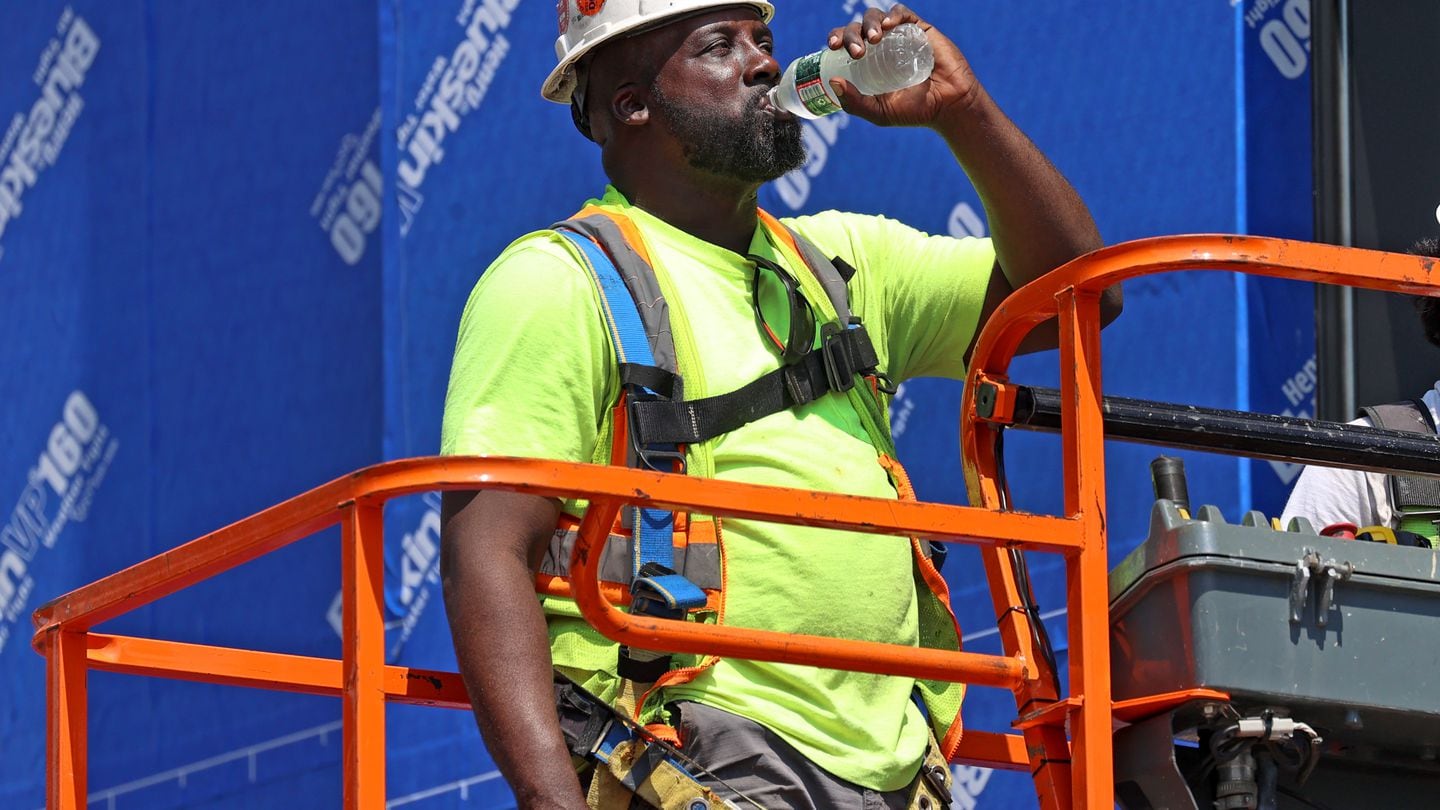 Barry Holder gulped water while working on a construction site on A Street in South Boston Wednesday. The New England power grid emergency comes as a potentially record-setting heat wave hits the Northeast,