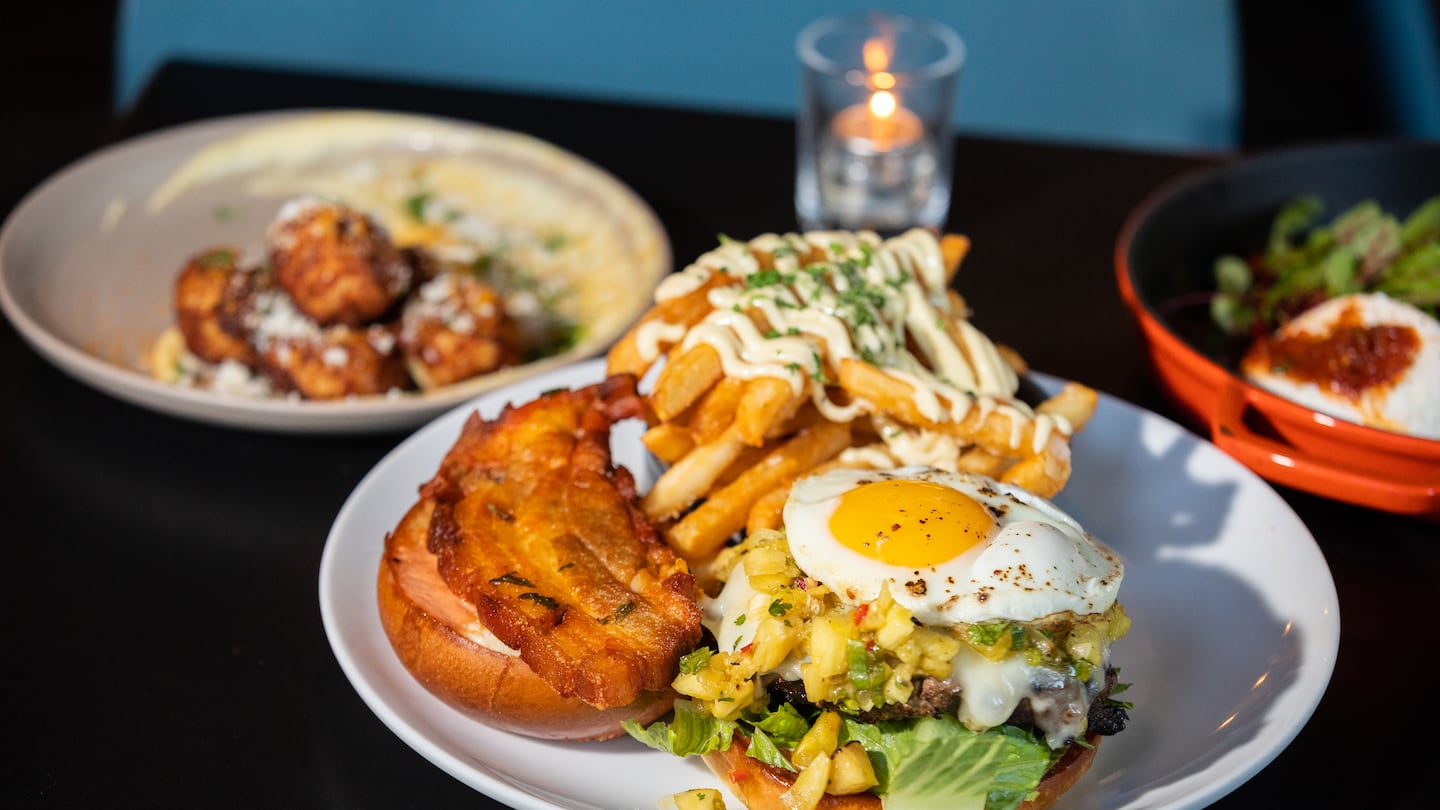 The Qué Mas burger served with Swiss cheese, grilled pineapple, fried egg chicharron, and salsa rosada at Qué Mas in Beverly.