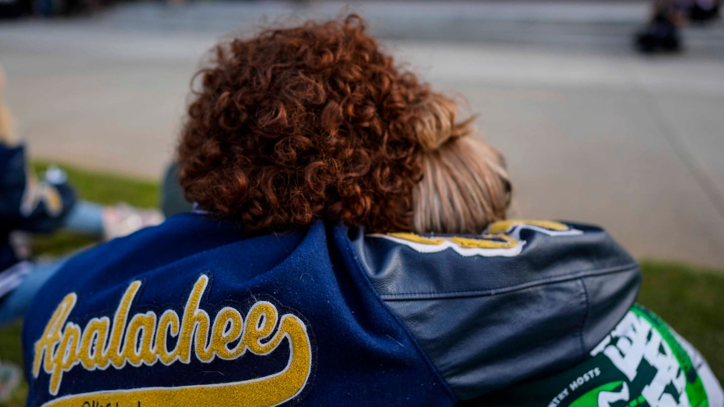 Mourners listen to a speaker during a candlelight vigil for the slain students and teachers at Apalachee High School, Sept. 4, in Winder, Ga.