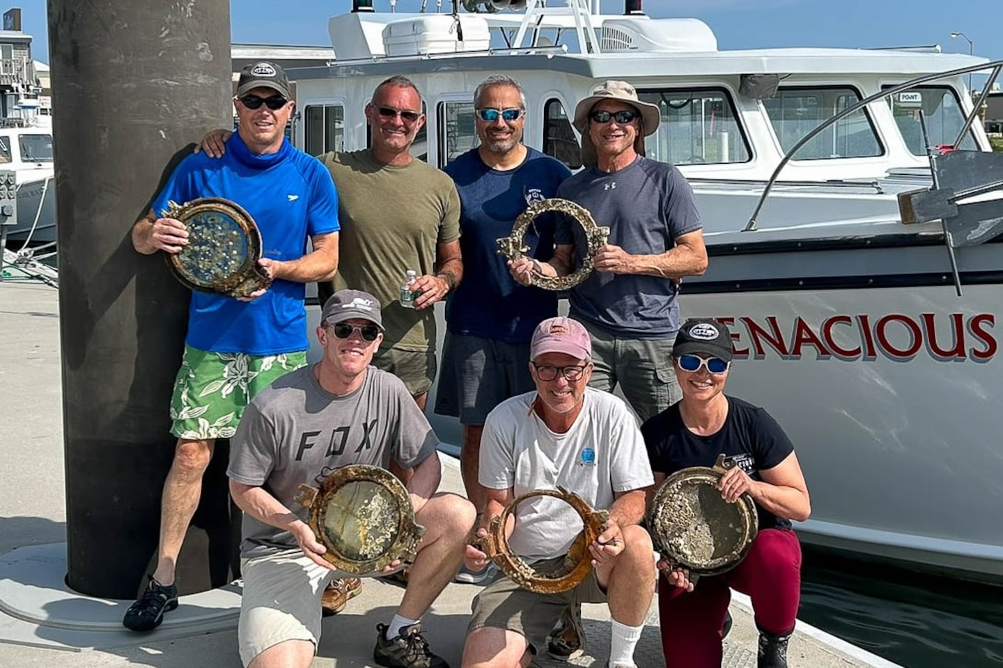 Members of the team from Atlantic Wreck Salvage held portholes pulled from the wreckage of Le Lyonnais, alongside the crew's boat, the D/V Tenacious.