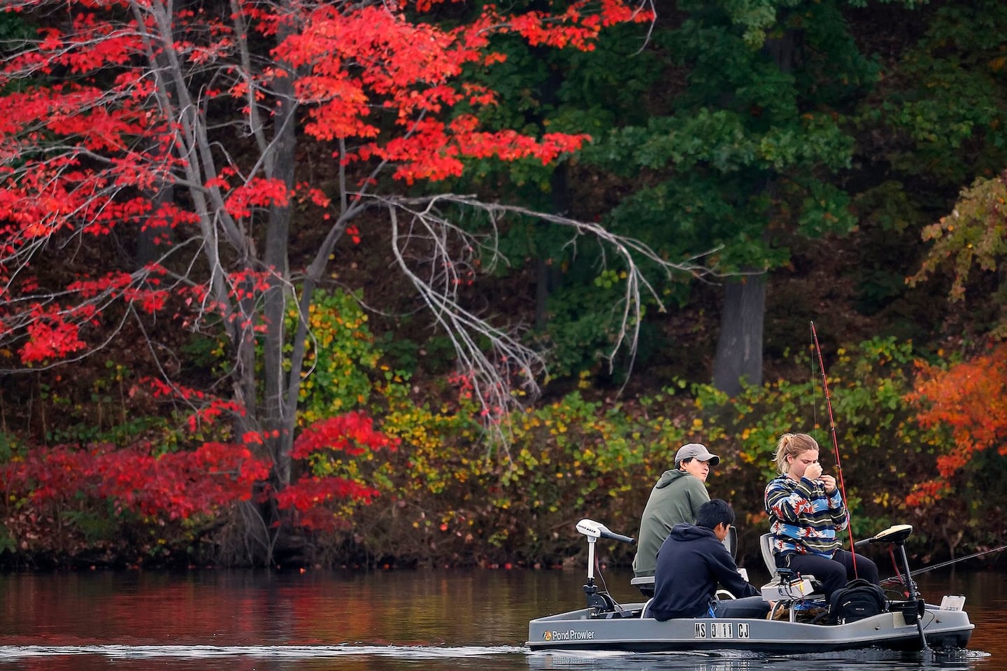 Anglers pass fall colors on Horn Pond in Woburn in October 2023.