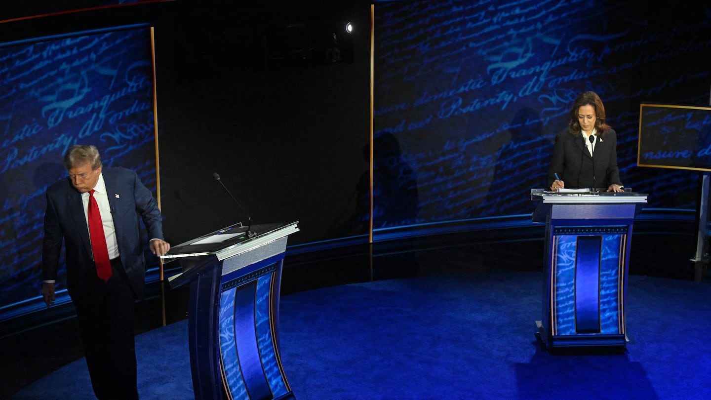 Former US President and Republican presidential candidate Donald Trump walks away during a commercial break as US Vice President and Democratic presidential candidate Kamala Harris take notes during a presidential debate at the National Constitution Center in Philadelphia, Pa., on Sept. 10.