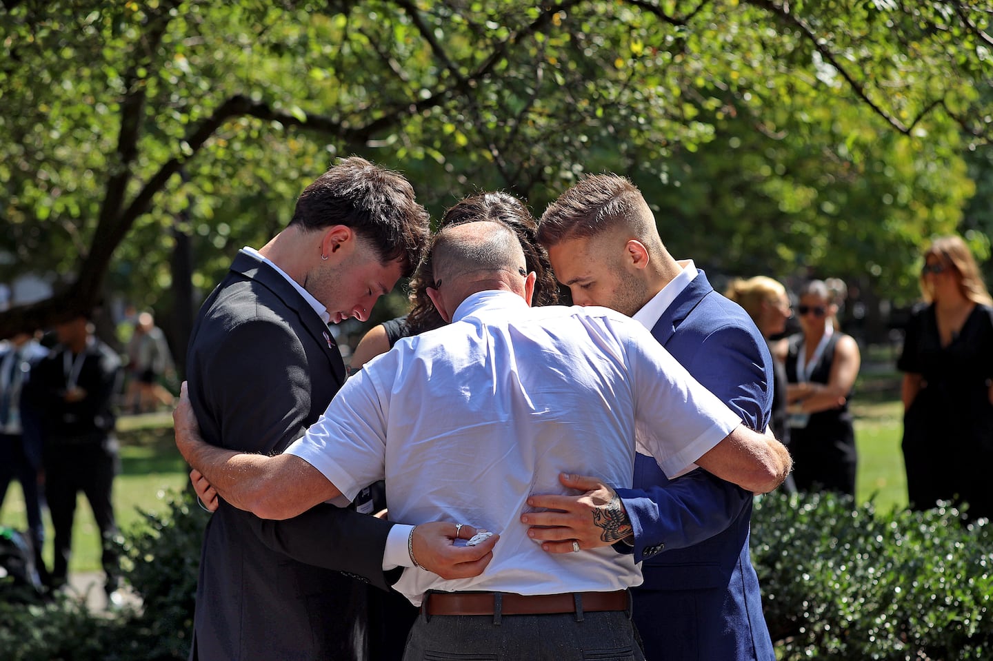 Family and friends hugged one another at the memorial during the September 11th wreath laying ceremony at the Boston Public Garden on Wednesday.