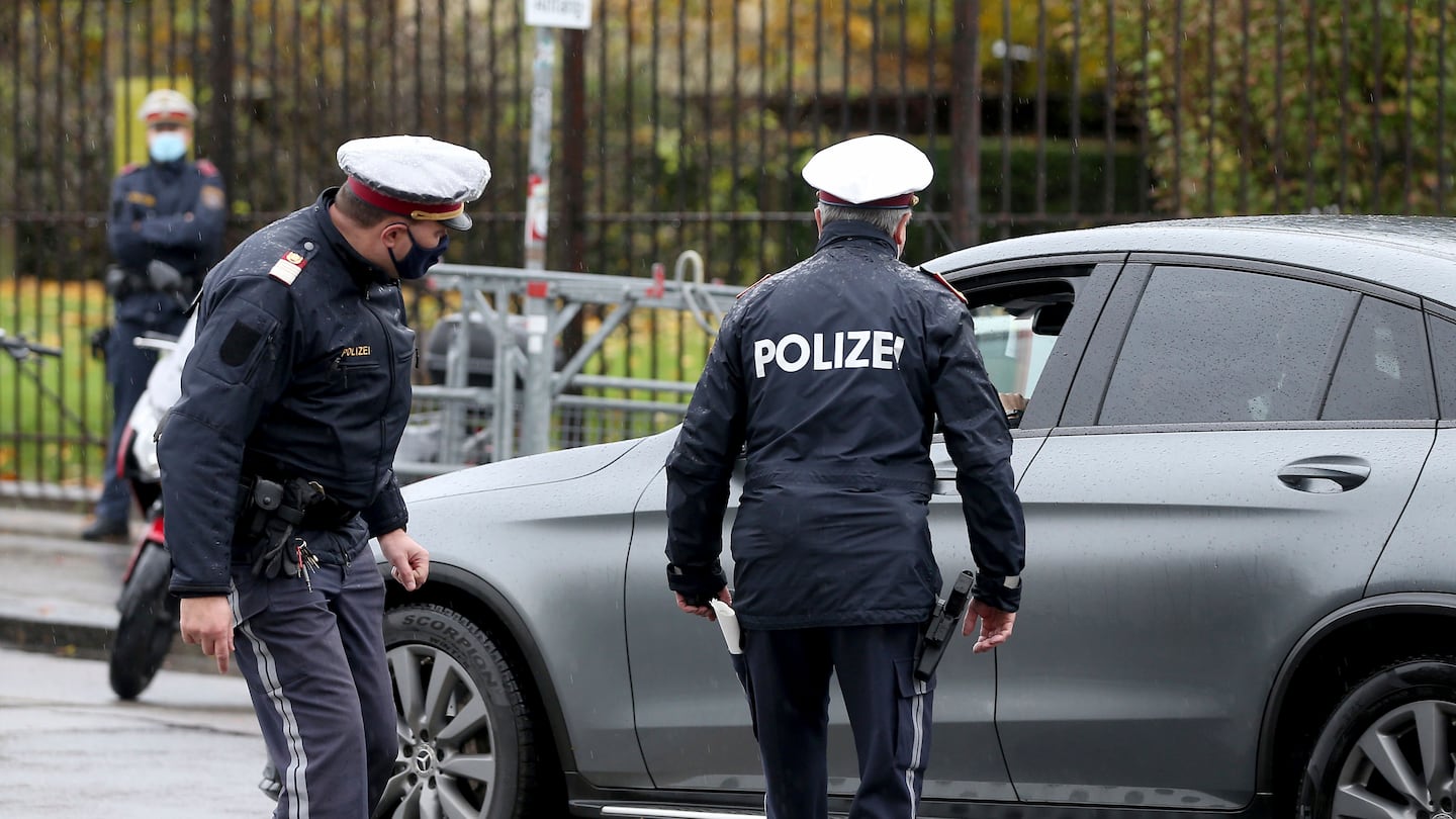 Police officers check a car in downtown Vienna, Austria, on Oct. 30.