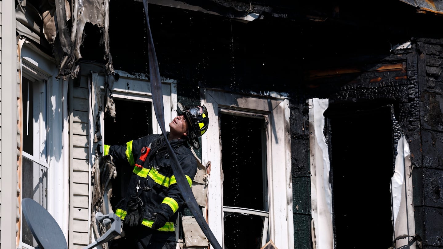 A firefighter investigated the aftermath of a multi-alarm fire on Aiken Avenue in Lowell.