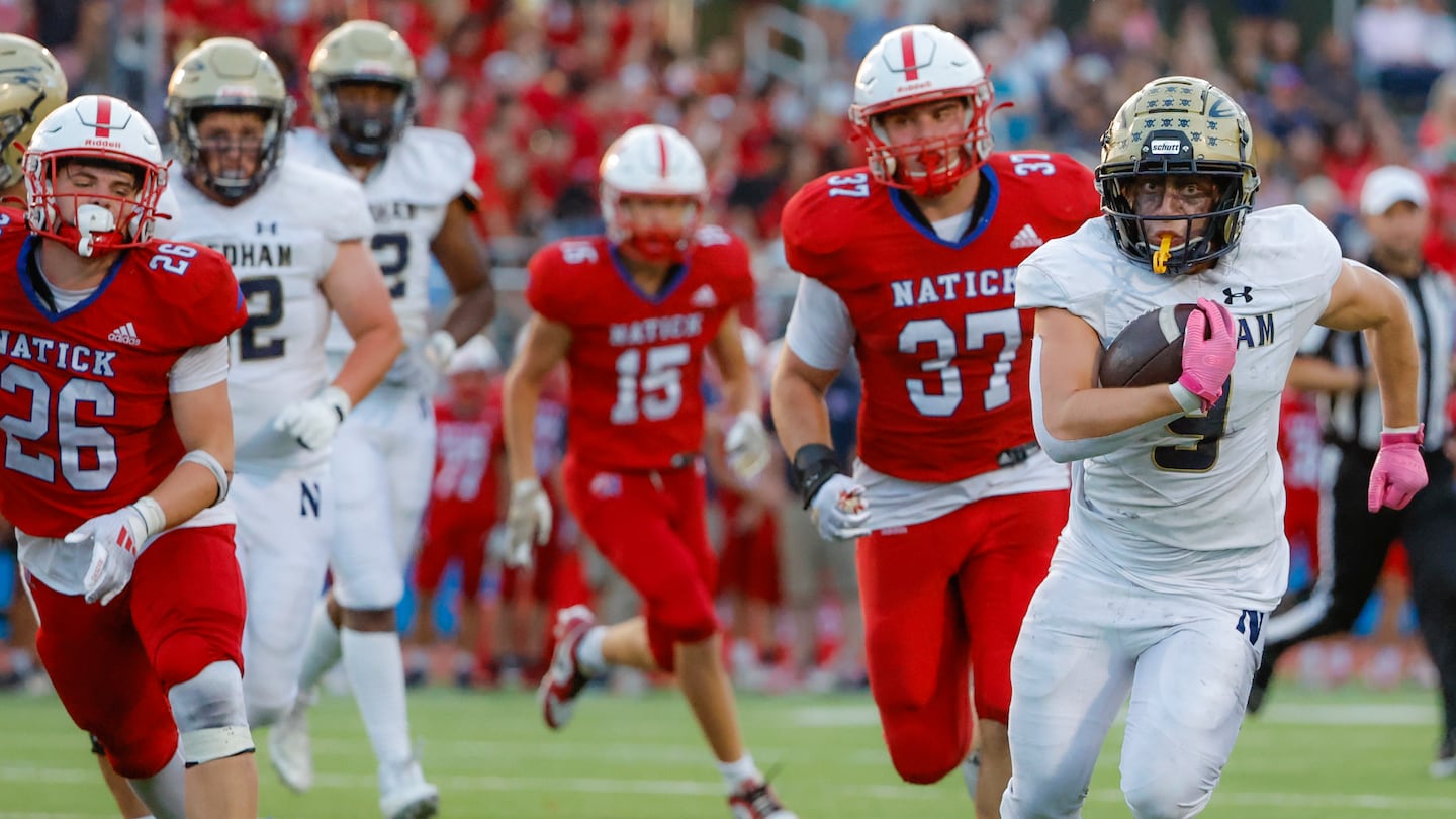 Needham's Stephen Rocamboli (right) leaves several Natick defenders in his wake on his 17-yard touchdown run during the first half of the Rockets' 20-7 victory Friday night.