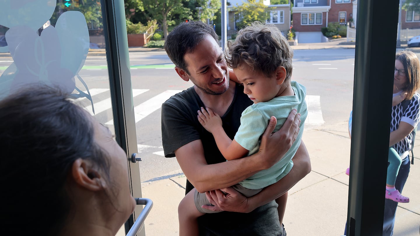 Teacher Laure Bouyon greeted Theo Lazarus and his dad Arnold Lazarus during drop off time at Capucine Montessori School in Cambridge.