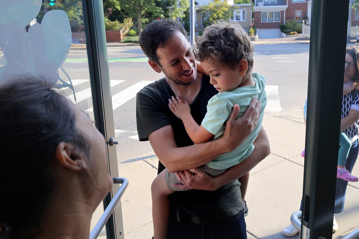 Teacher Laure Bouyon greeted Theo Lazarus and his dad Arnold Lazarus during drop off time at Capucine Montessori School in Cambridge.