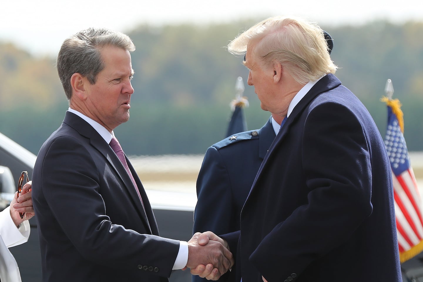 Georgia Governor Brian Kemp (left) greeted then-President Donald Trump as he arrives at Dobbins Air Reserve Base in November 2019, in Marietta, Ga.