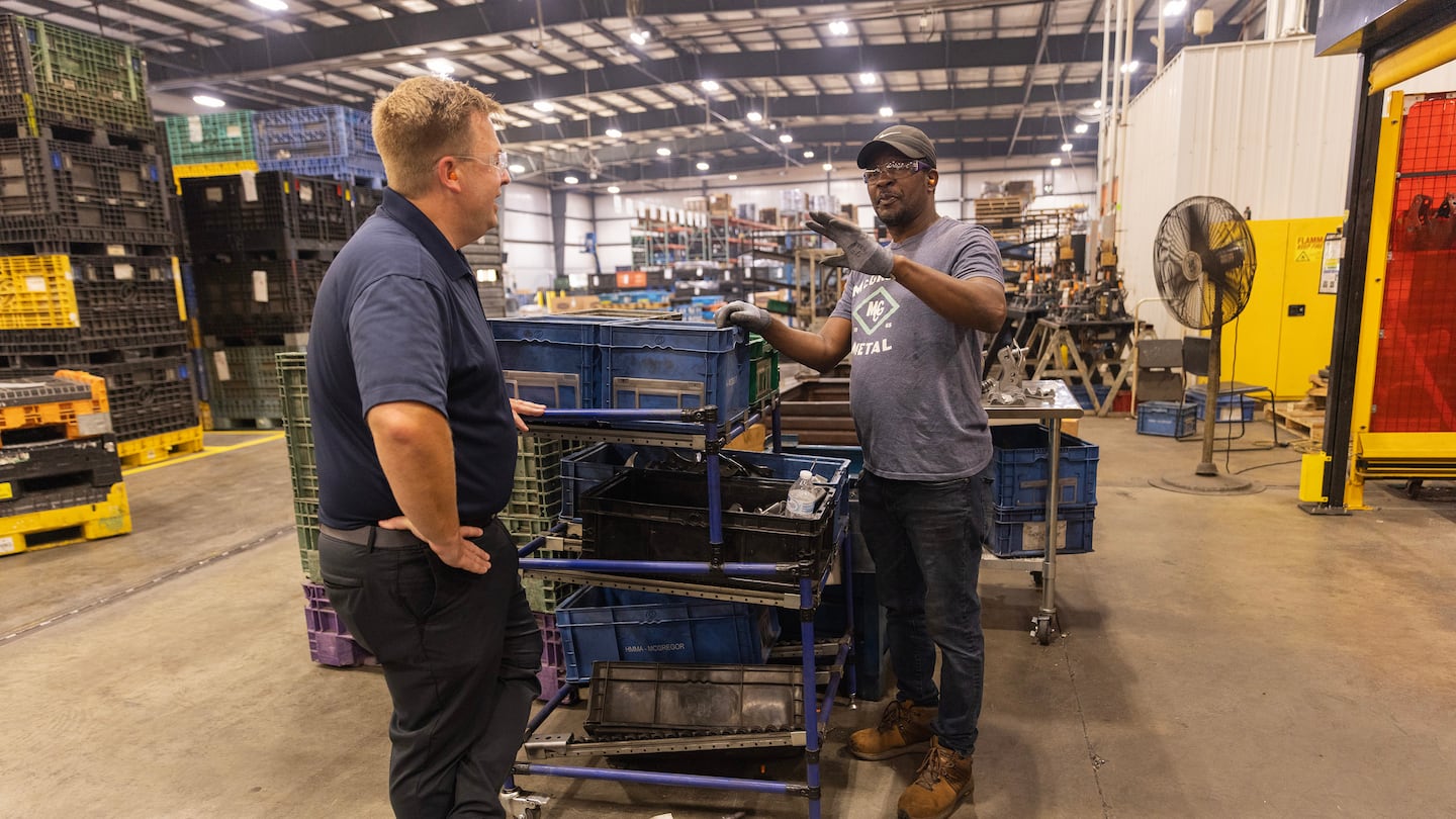 Jamie McGregor, left, the chief executive of McGregor Metal, an automotive parts maker, spoke with Daniel Campere, a Haitian worker, in Springfield, Ohio on Aug. 26.