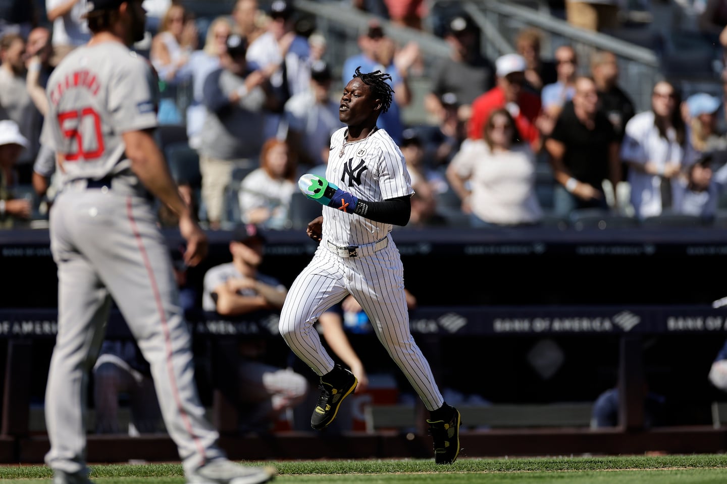 The Yankees' Jazz Chisholm Jr. (right) scores during the second inning off an RBI double from Giancarlo Stanton off Kutter Crawford (left).