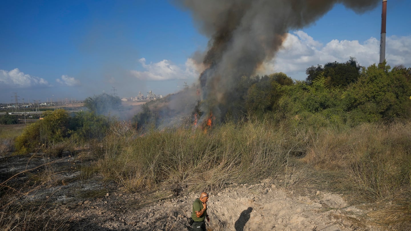 A police officer inspects the area around a fire after the military said it fired interceptors at a missile launched from Yemen that landed in central Israel on Sept. 15.