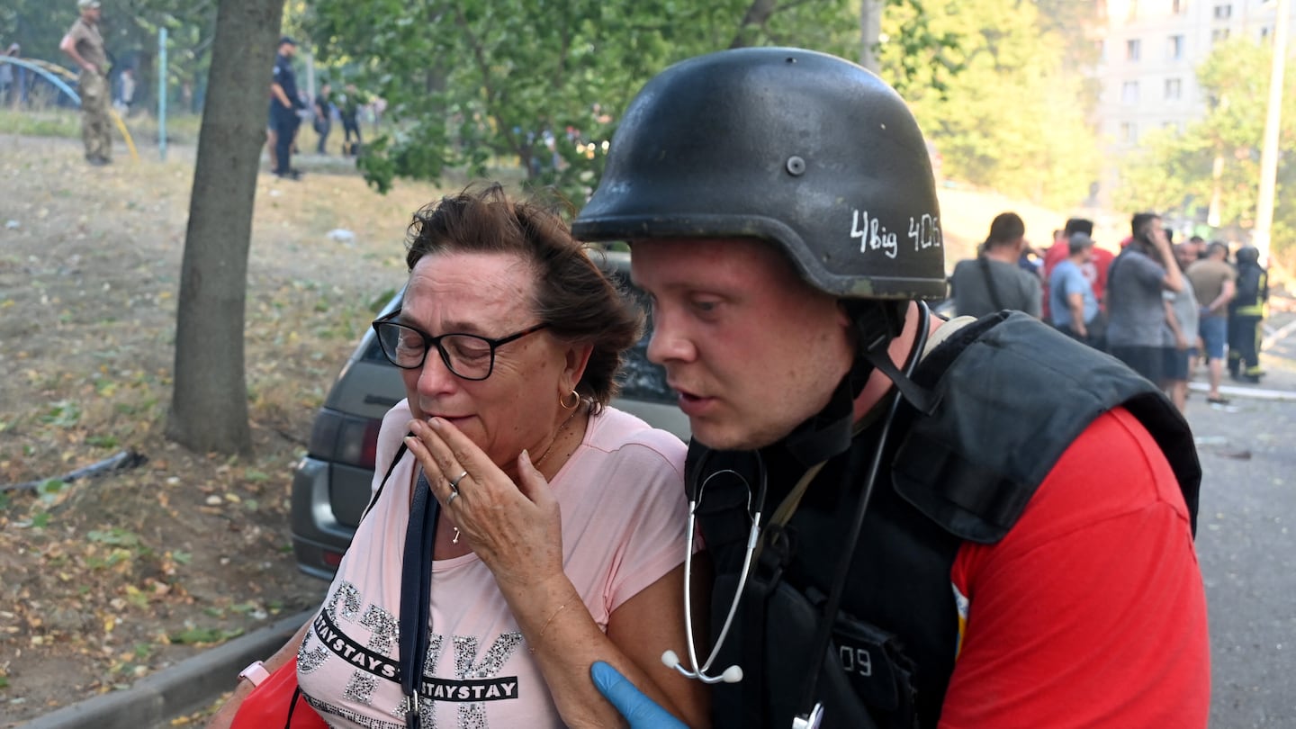 A Ukrainian medic helped a woman evacuate the site of a missile attack in Kharkiv Sunday amid the Russian invasion of Ukraine.