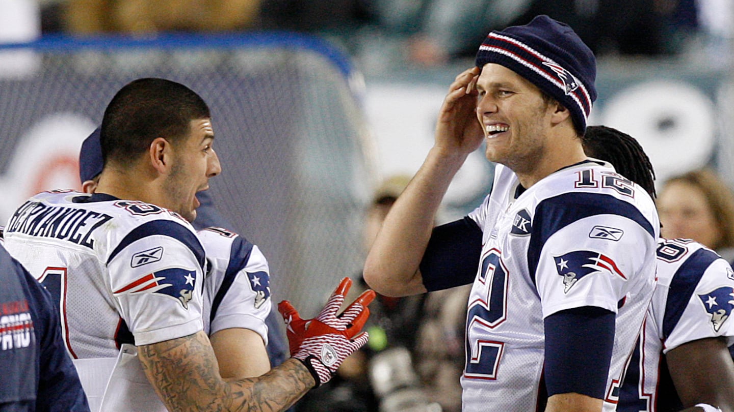 Aaron Hernandez talks to Tom Brady on the sidelines during a game in 2011.