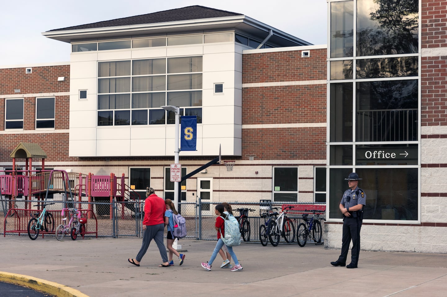 An Ohio state trooper stands guard as children arrive for the school day at Snowhill Elementary School in Springfield, Ohio, on Tuesday morning, Sept. 17, 2024.