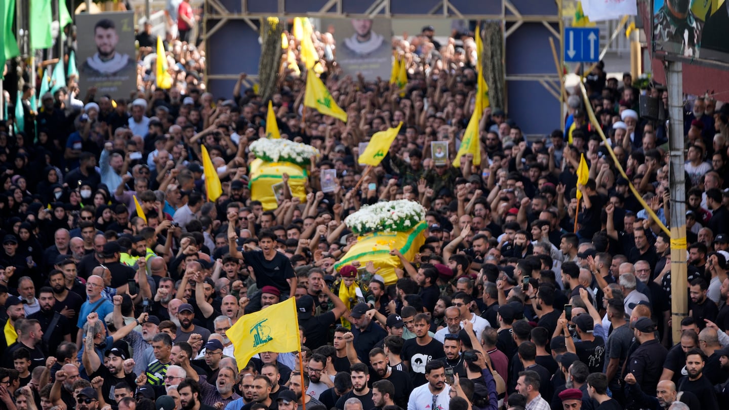 Hezbollah members carried the coffins of two of their comrades who were killed on Wednesday when a handheld device exploded during a funeral procession in the southern suburbs of Beirut on Thursday.