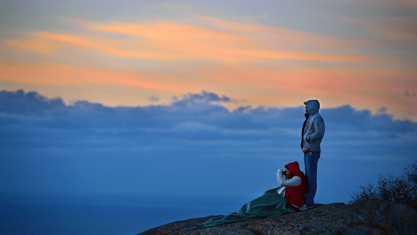 People watch the sunrise from Cadillac Mountain at Acadia National Park in 2014.