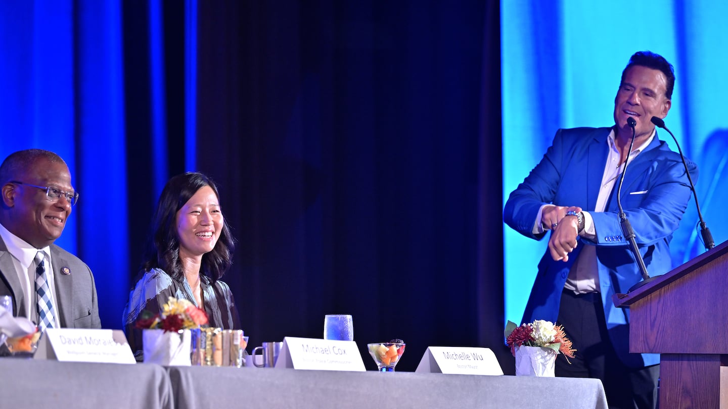 Emcee Alberto Vasallo, III CEO and President of El Mundo Boston, jokes that Mayor Michelle Wu, arrived late due to a BPS school bus as Police Commissioner Michael Cox looks on during the Hispanic Heritage Breakfast hosted by El Mundo Boston at the Park Plaza Hotel.