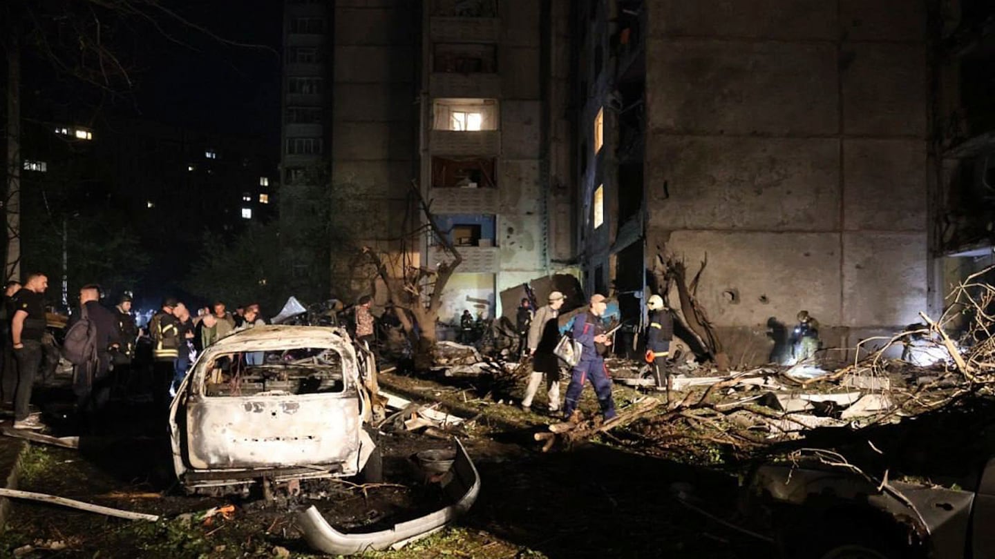 People mill around damaged cars and debris after a Russian strike on a residential building in Kharkiv, Ukraine, on Sept. 22.