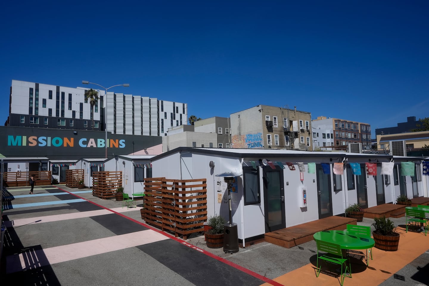 A person walks under a Mission Cabins sign at the Five Keys transitional housing location in San Francisco, on Aug. 26.