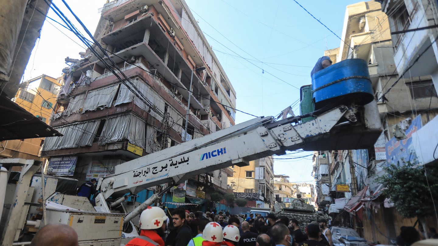 Rescuers worked in a street under a residential building whose top two floors were hit by an Israeli strike in the Ghobeiri area of Beirut's southern suburbs on Tuesday.