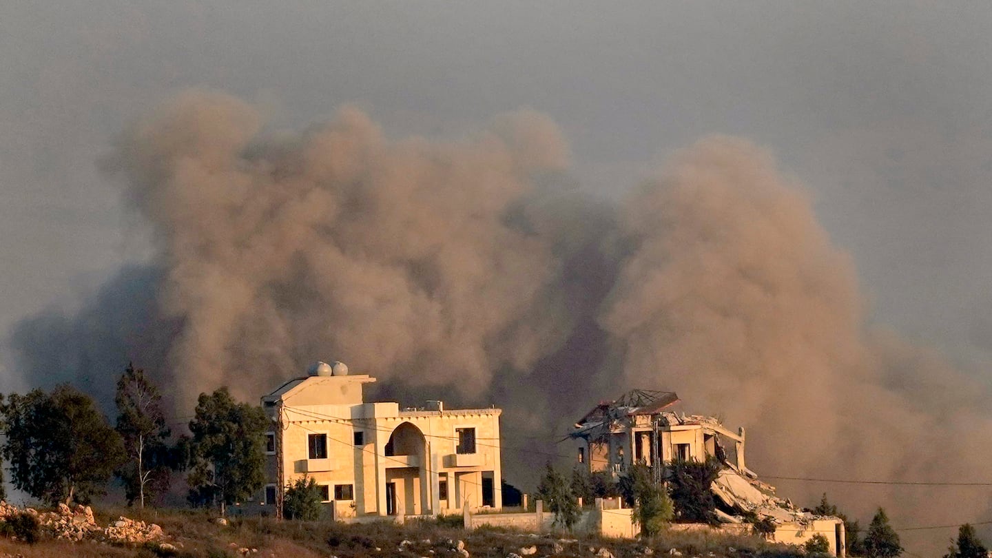 Smoke rises behind a destroyed house following an Israeli airstrike on Khiam village, as seen from Marjayoun town, south Lebanon, on Sept. 24.