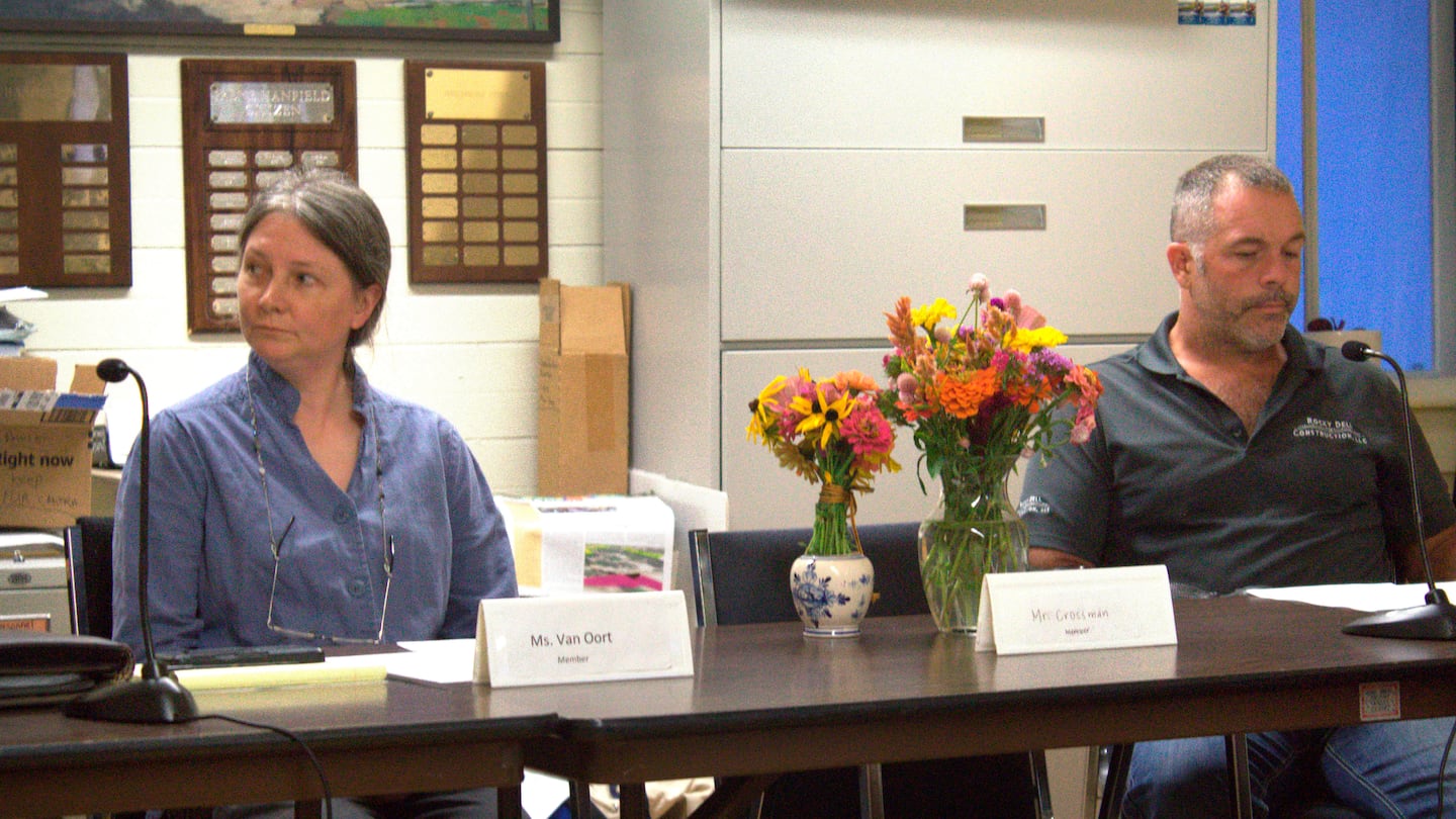 On Sept. 17, Pawlet Select Board members Jessica Van Oort and Rich Hulett sat next to the seat and flowers remembering slain Select Board member Brian Crossman Sr., who along with his wife and son were found shot to death in their home.