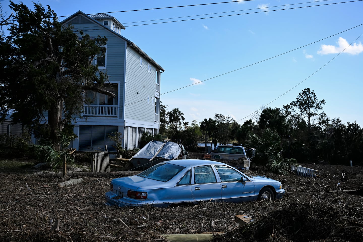 Debris surrounds a damaged car after Hurricane Helene made landfall in Steinhatchee, Florida, on September 27, 2024.