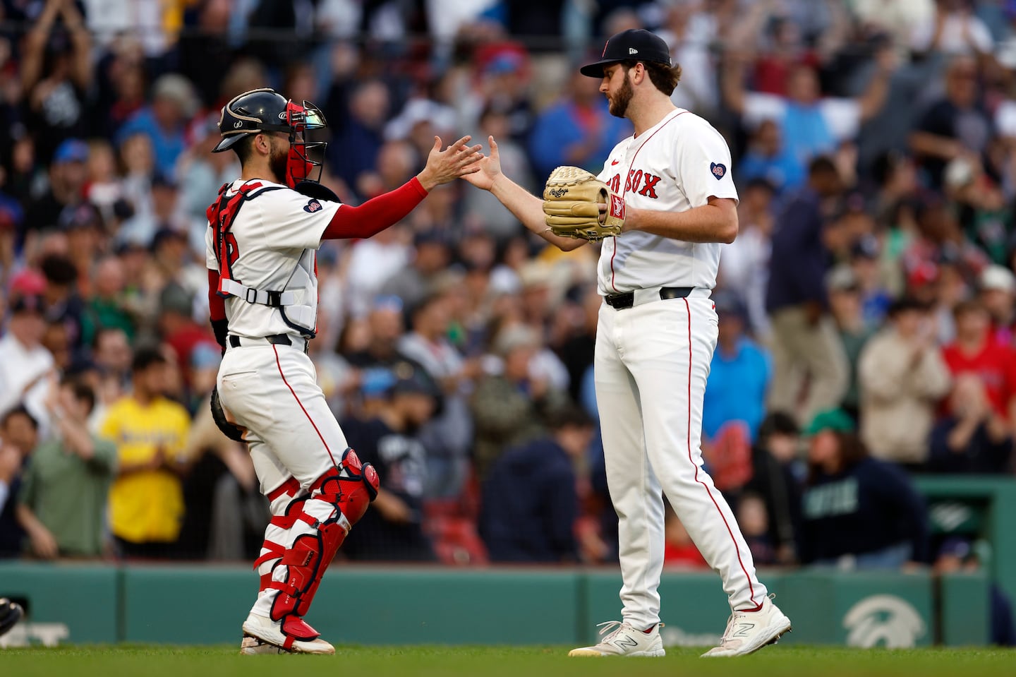 Red Sox catcher Connor Wong (left) and reliever Justin Slaten high-five after closing out the season-ending 3-1 win over the Rays Sunday at Fenway Park, evening Boston's record at 81-81 for the 2024 campaign.