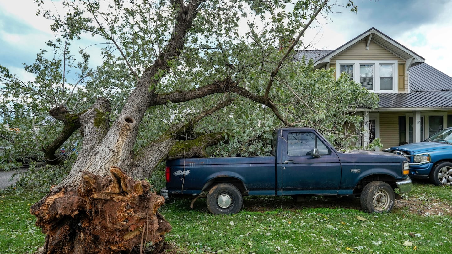 An uprooted tree landed on a pickup truck in front of a home on East Main Street after Hurricane Helene, Sept. 28, in Glen Alpine, N.C.