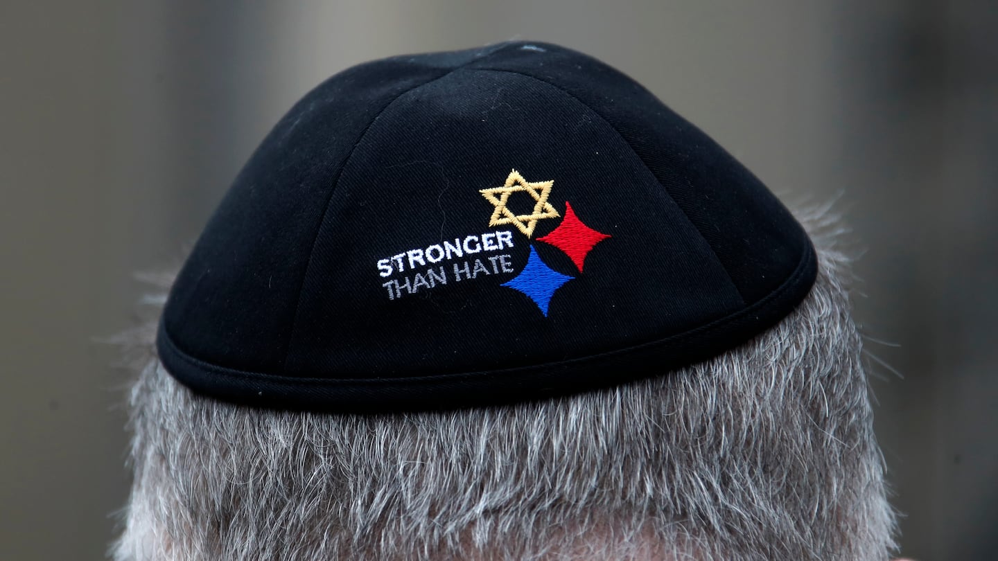 A man wearing a "Stronger Than Hate" yarmulke outside the Tree of Life synagogue in Pittsburgh, where 11 Jews were massacred in 2018.